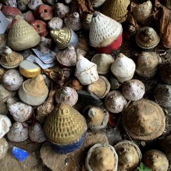 Tsa-tsas offered at a path-side shrine.