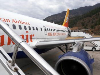 Group members board plane for flight from Paro to Delhi.